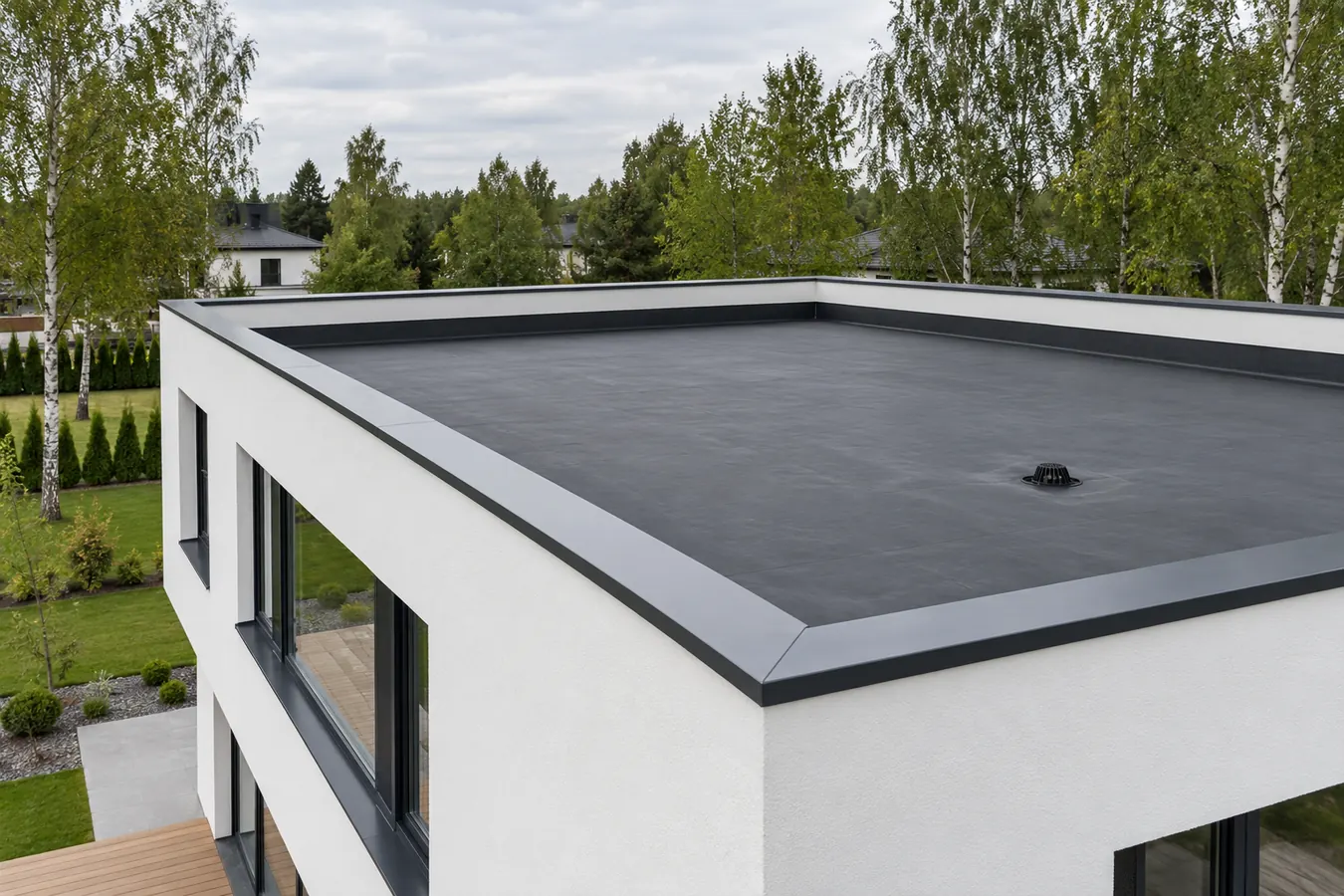 Plakanais jumts, pārklāts ar vienlaidu melnu EPDM membrānu, kas uzlocīta uz parapeta, ar jumta noteku